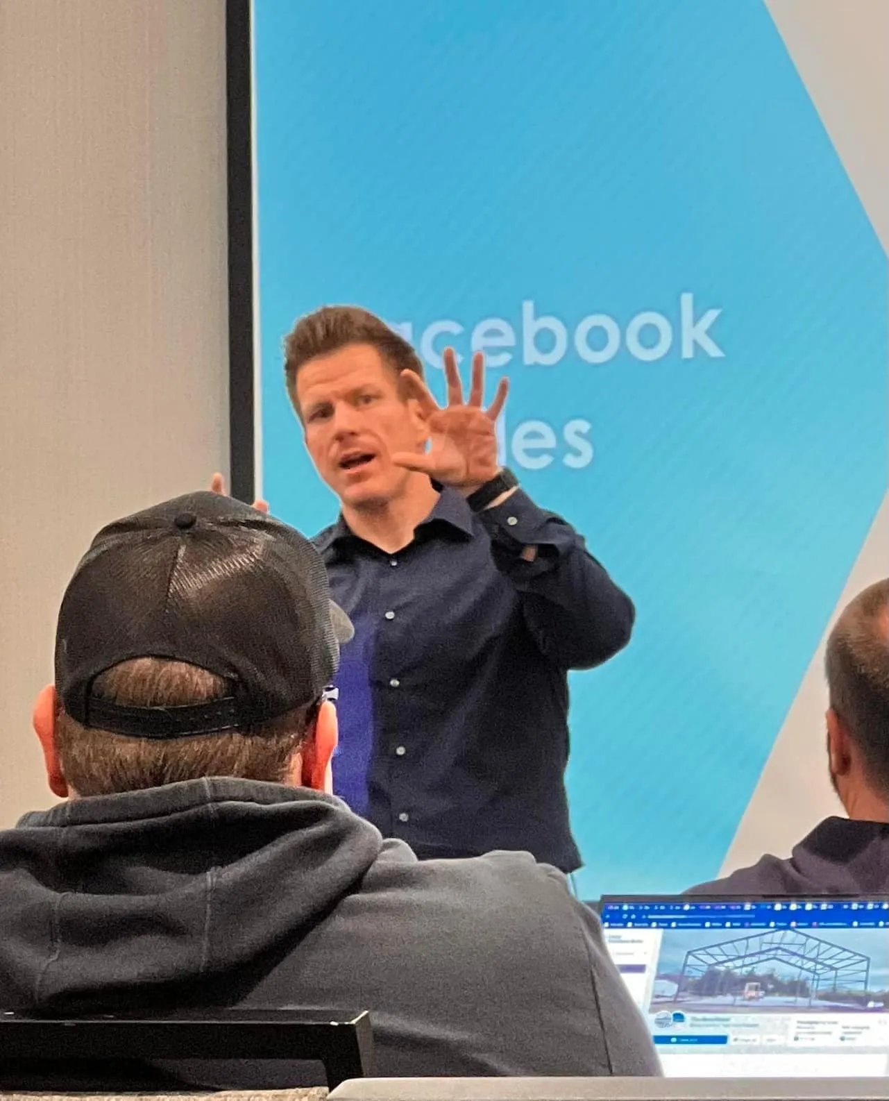 Jared Guynes presenting social media strategy slides to a full classroom